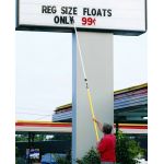 Person changing letters on an outdoor marquee sign with a letter pole